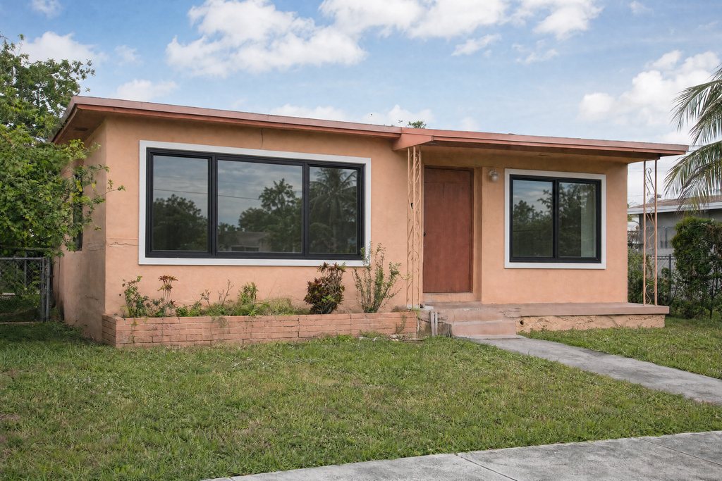 South Florida home with new black-framed impact windows (illustrative rendering)